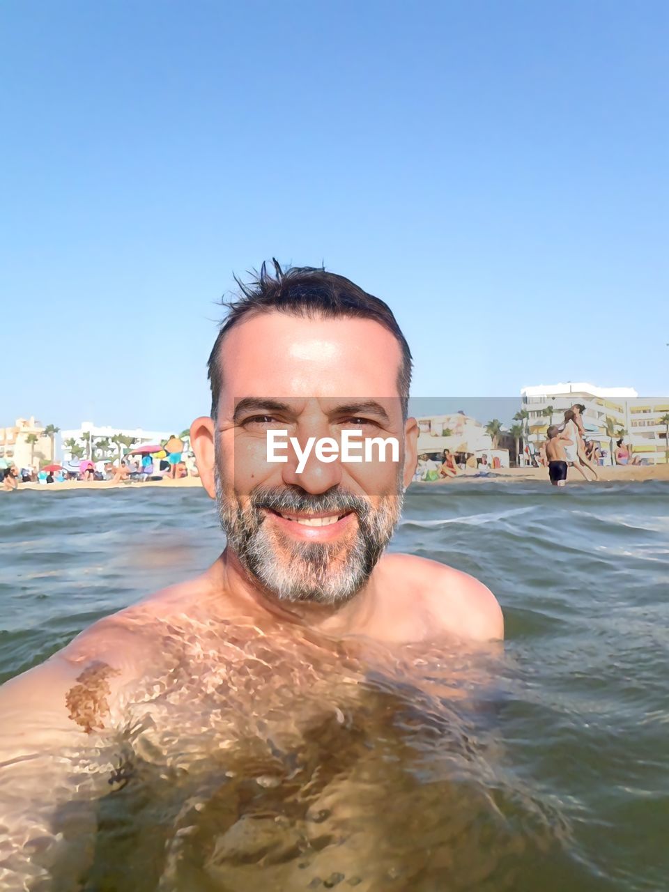 water, portrait, adult, vacation, one person, men, sky, nature, sea, swimming, clear sky, looking at camera, beard, trip, smiling, facial hair, holiday, headshot, leisure activity, happiness, sunny, sunlight, blue, front view, mature adult, day, beach, lifestyles, enjoyment, travel destinations, travel, land, outdoors, emotion, ocean, summer, copy space, relaxation, fun, human face, cheerful, young adult, tourism, waist up, sports