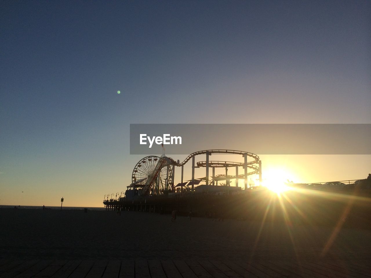 Silhouette amusement park during sunset