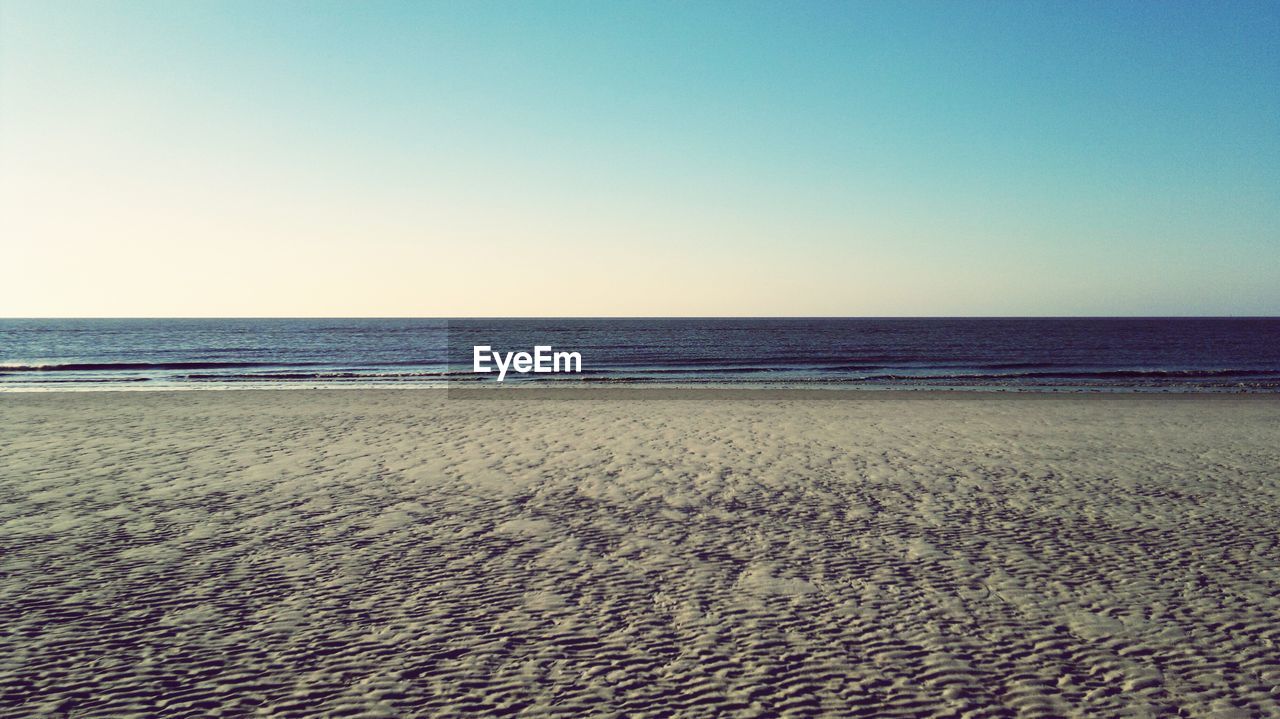 Scenic view of beach against blue sky