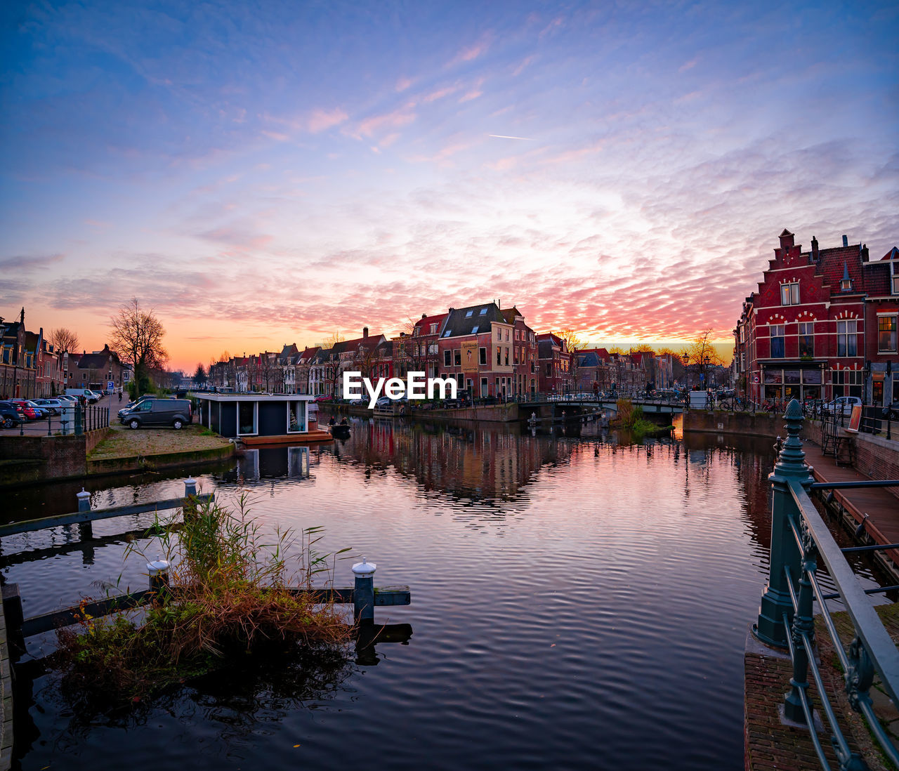 CANAL AMIDST BUILDINGS IN CITY AGAINST SKY