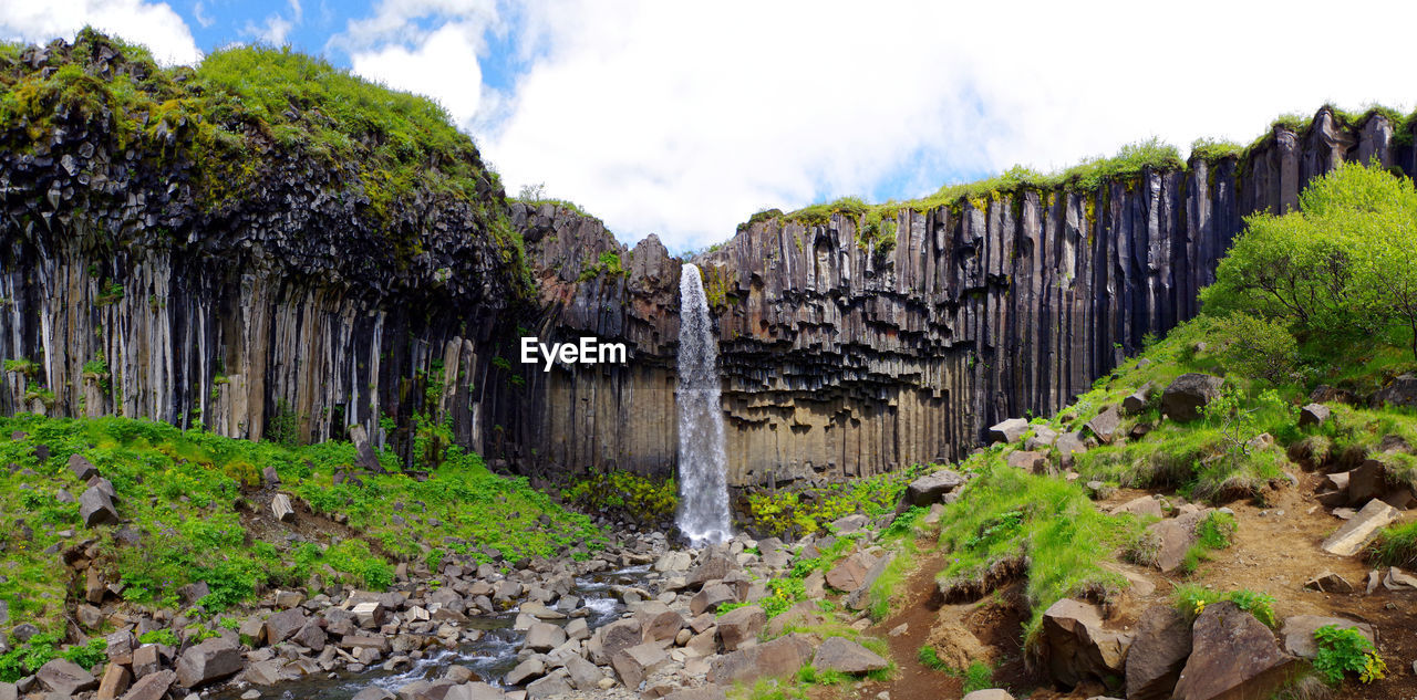 Panoramic view of waterfall against sky