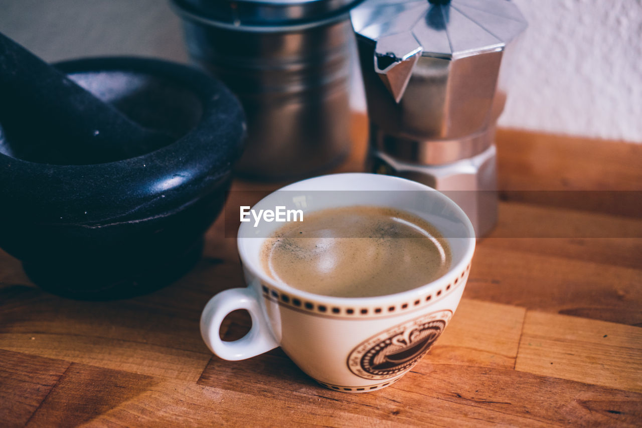 HIGH ANGLE VIEW OF COFFEE CUP ON TABLE AT HOME