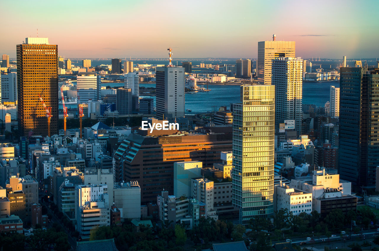 High angle view of modern buildings against sky in city during sunset