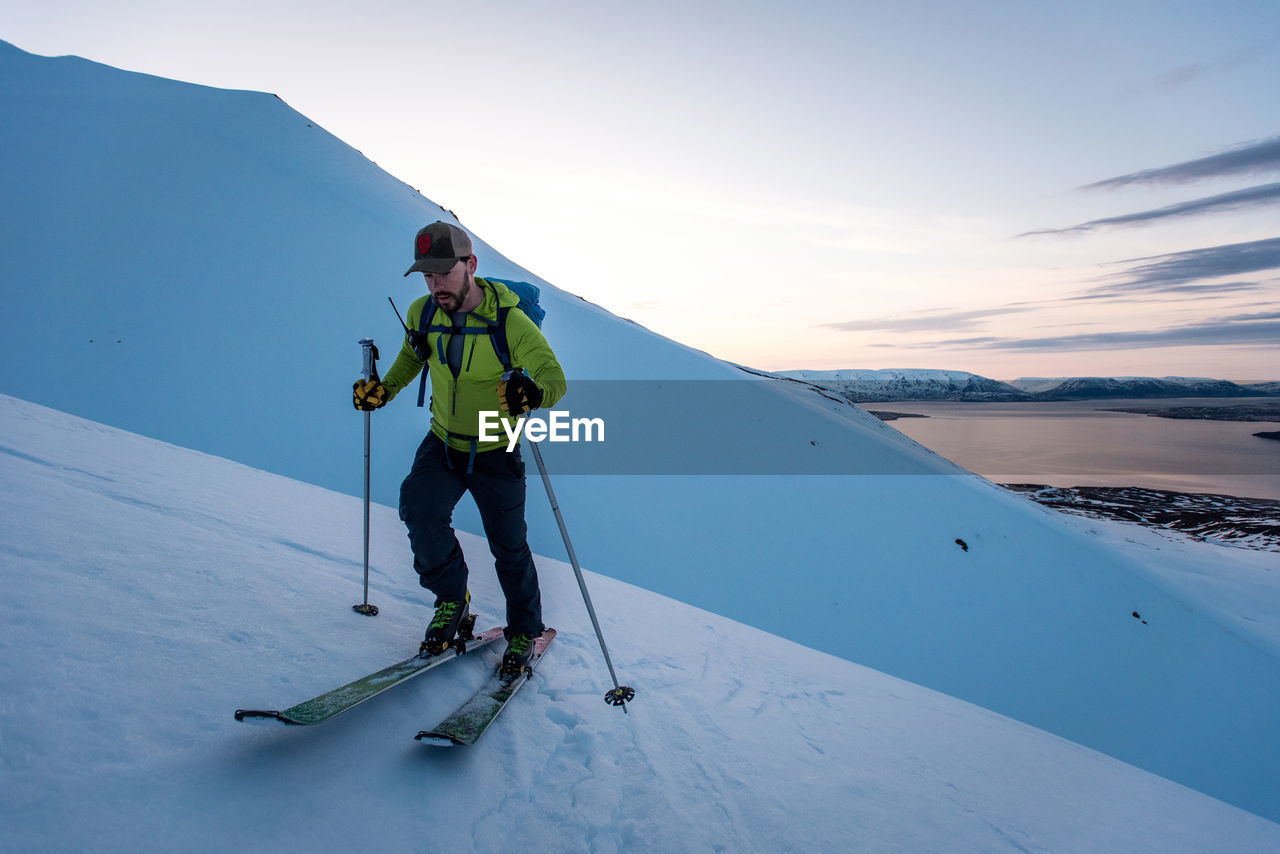 Man backcountry skiing in iceland at sunrise