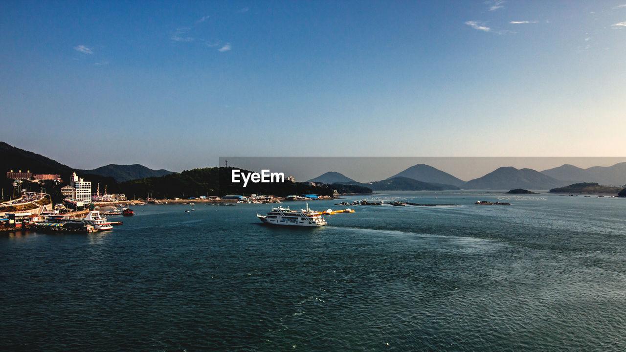 BOATS MOORED ON SEA AGAINST CLEAR SKY