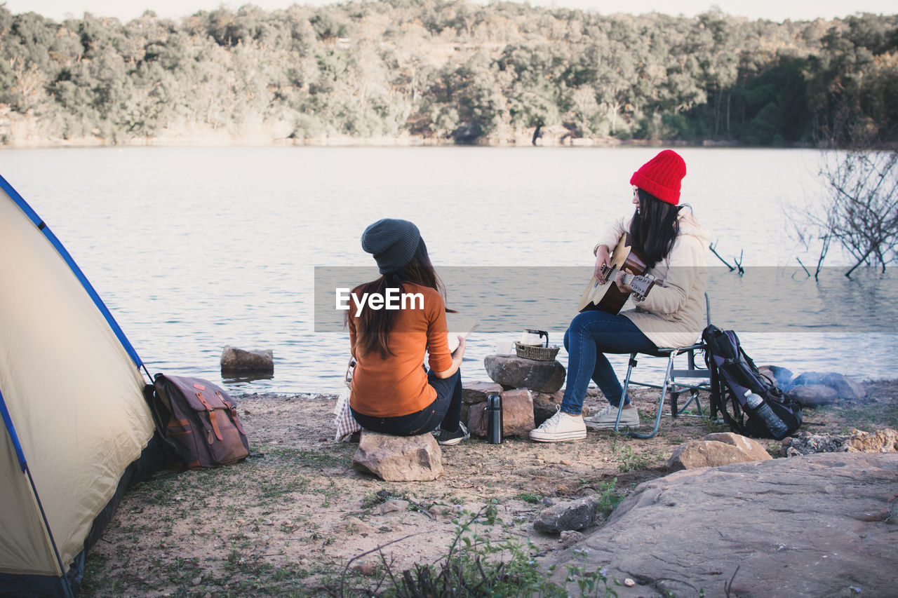 Friends enjoying by lake during camping