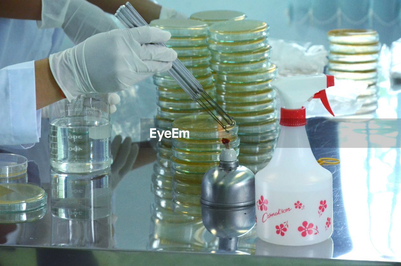 CLOSE-UP OF HAND HOLDING BOTTLES