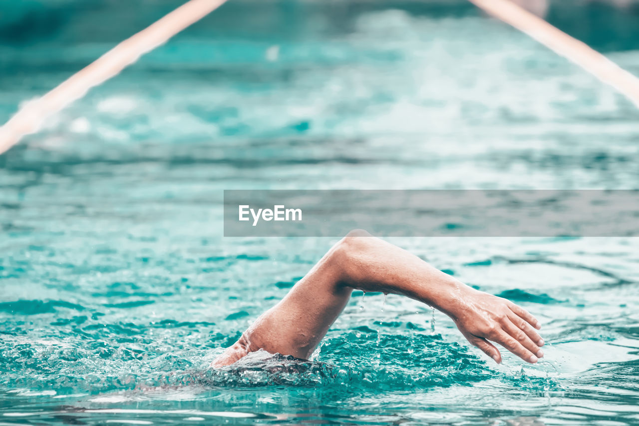 REFLECTION OF MAN SWIMMING IN POOL