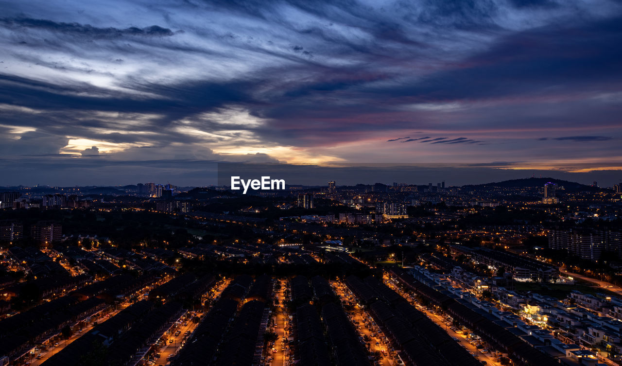 High angle view of illuminated city at sunset