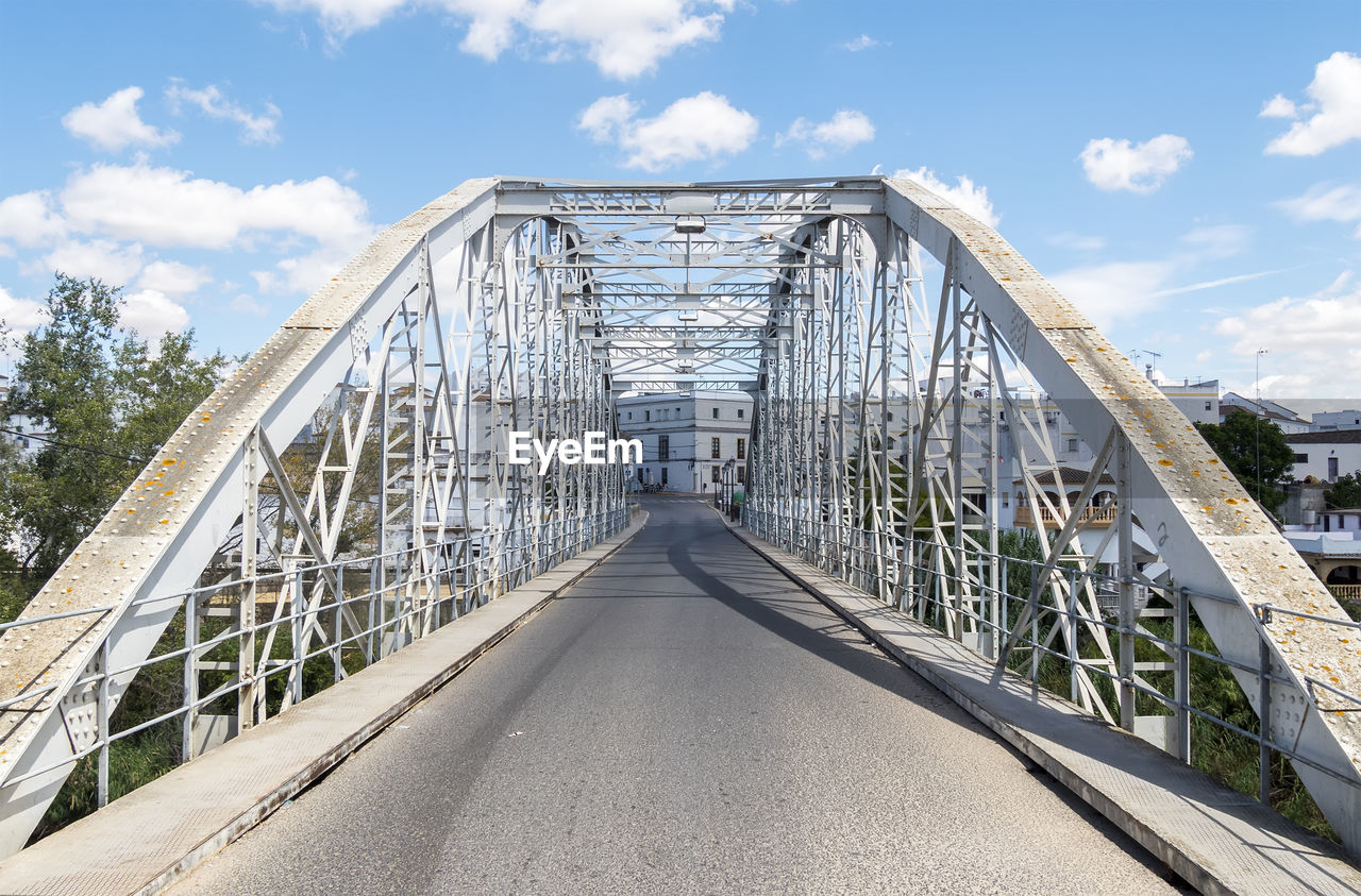architecture, bridge, sky, built structure, cloud, transportation, nature, city, the way forward, travel destinations, landmark, day, outdoors, road, no people, travel, diminishing perspective, arch bridge, cable-stayed bridge, walkway, water, blue, tourism, landscape, building exterior, vanishing point, sunlight