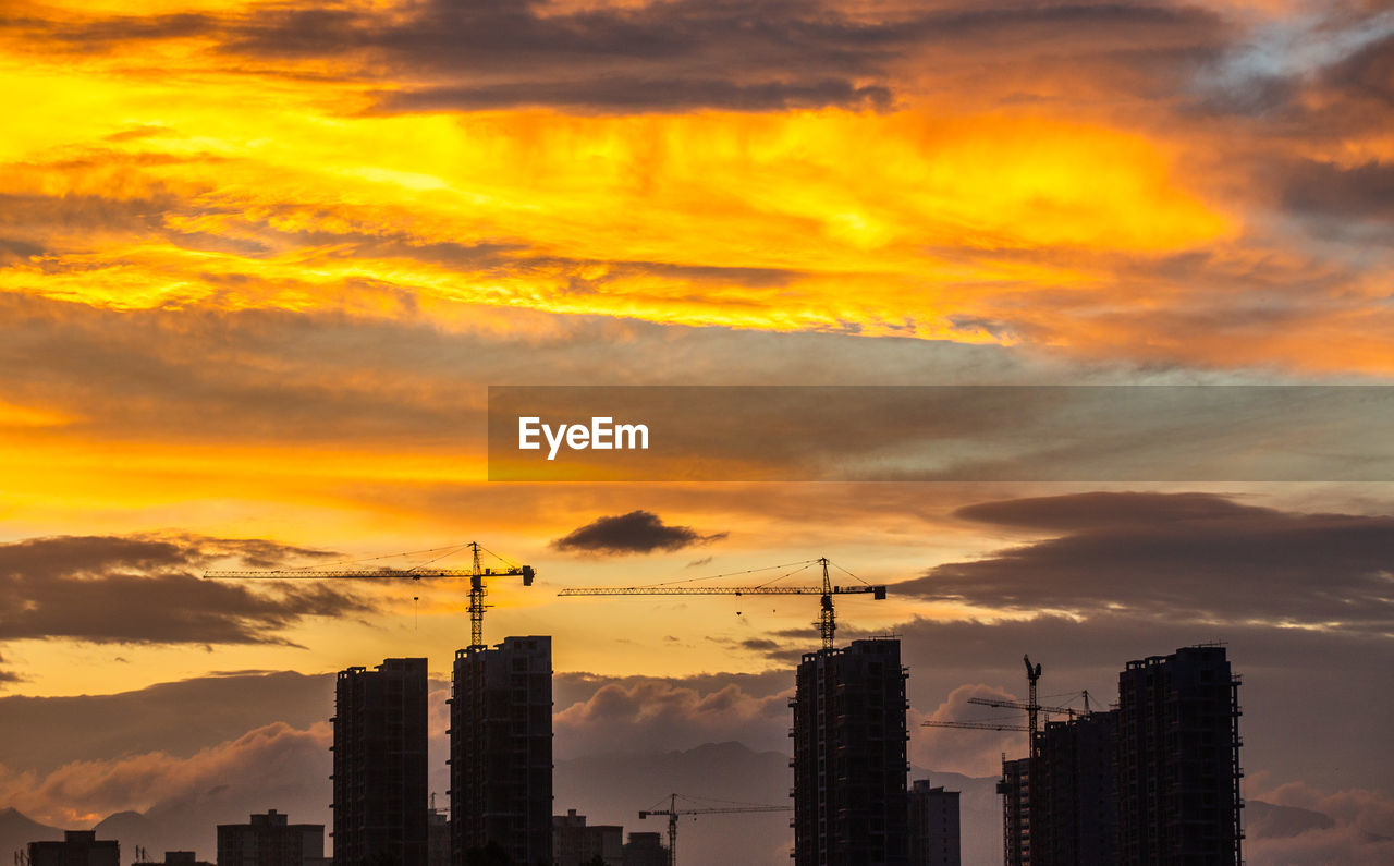 sky, sunset, architecture, horizon, city, afterglow, built structure, building exterior, cloud, skyline, dawn, landscape, building, urban skyline, skyscraper, office building exterior, evening, nature, cityscape, dramatic sky, orange color, silhouette, red sky at morning, city life, construction industry, outdoors, development, no people, business finance and industry, residential district, sunlight, tower, environment, industry, beauty in nature, travel destinations, cloudscape, business, downtown district, sun, scenics - nature, yellow, travel, office