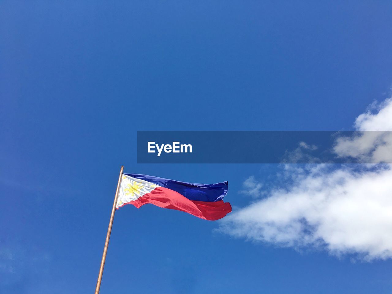 Low angle view of philippine flag against blue sky