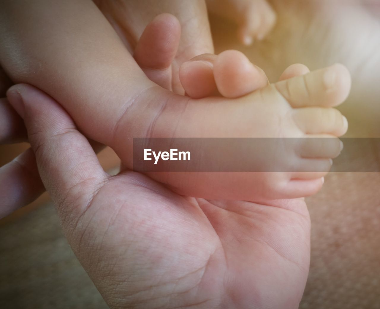 CLOSE-UP OF HANDS HOLDING BABY