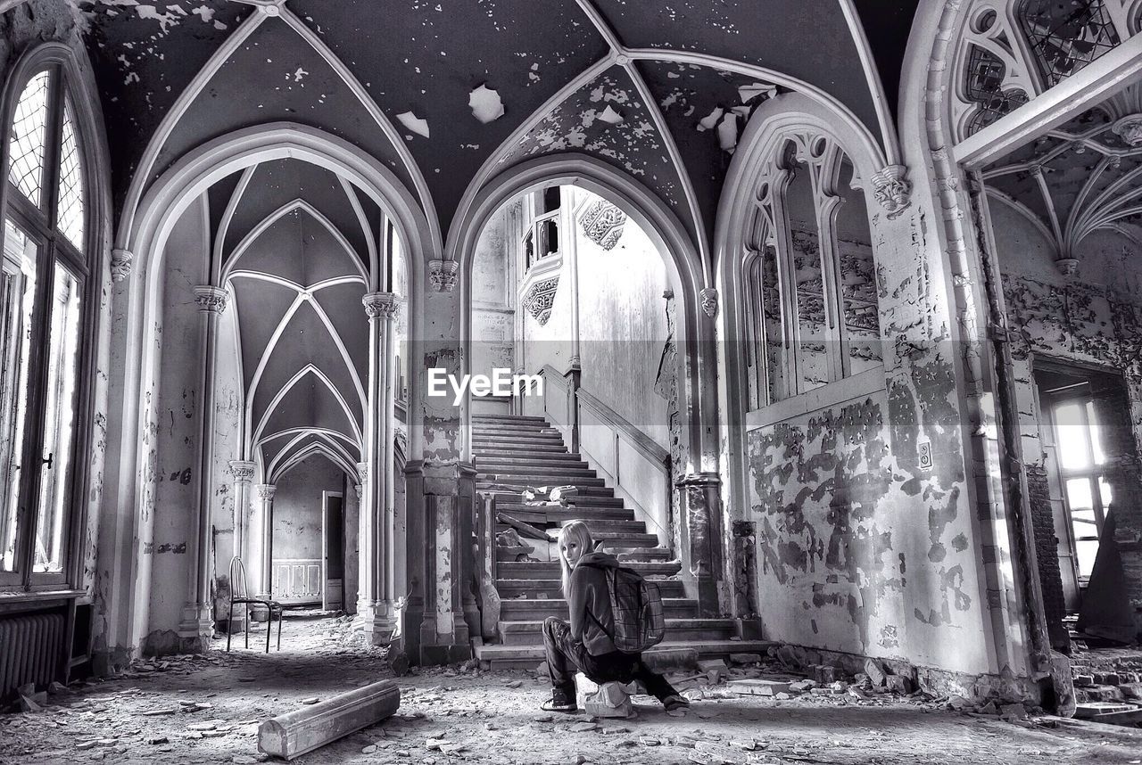 Young woman sitting in abandoned church