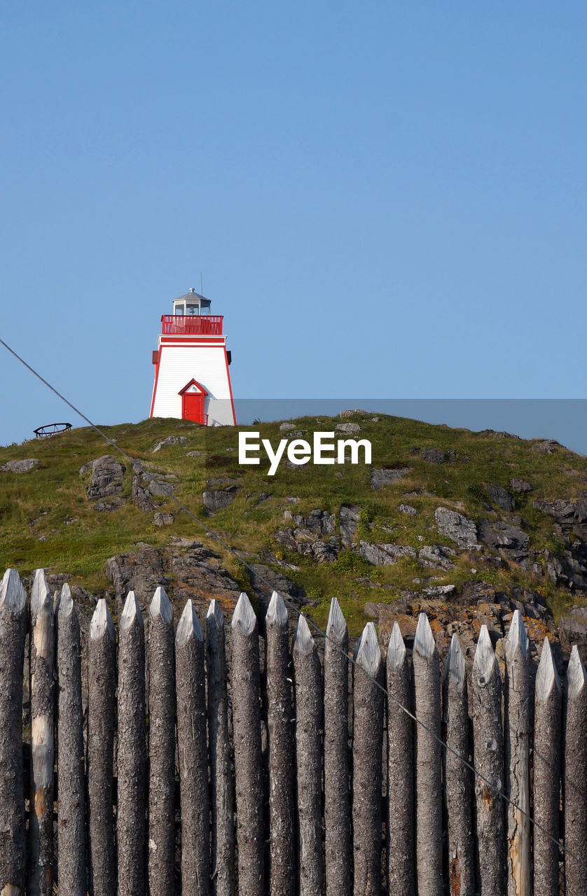 Lighthouse and post fence on blue sky