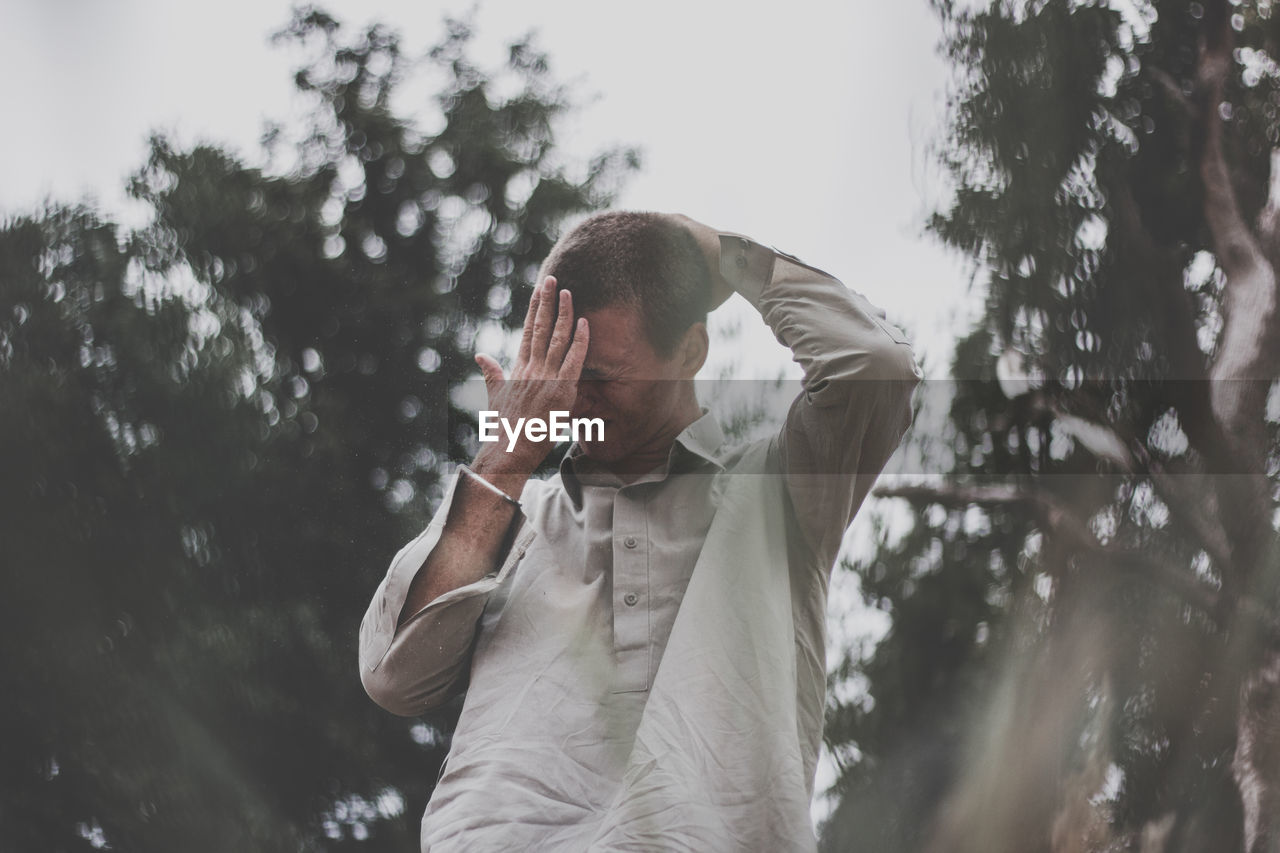 Low angle view of man standing in forest