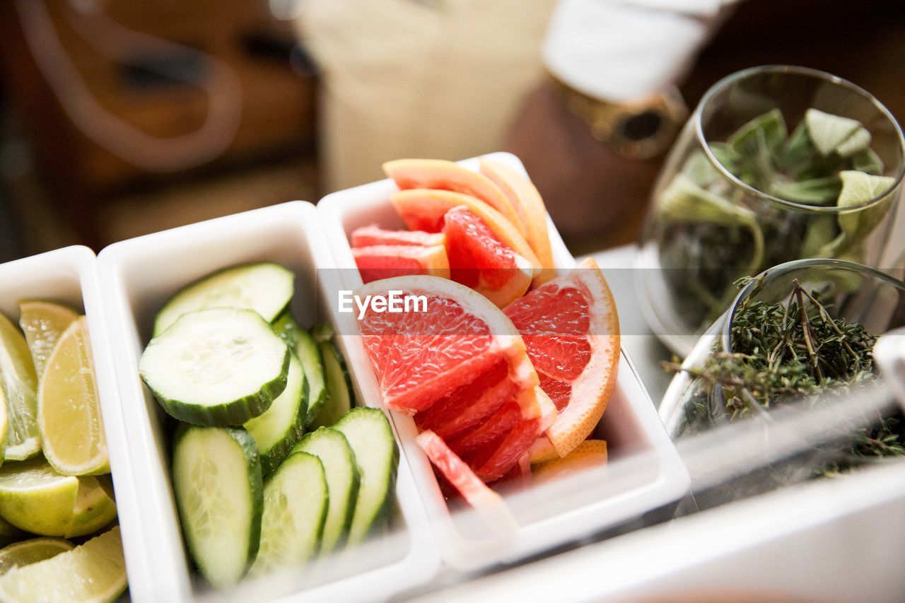 Slice of cucumber and citrus fruit with glass of leaf
