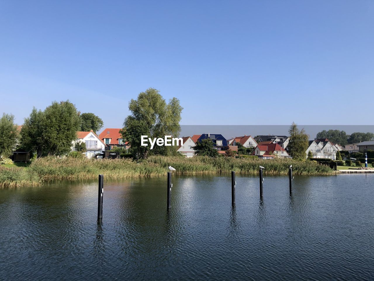 Houses by the lake against a blue sky 