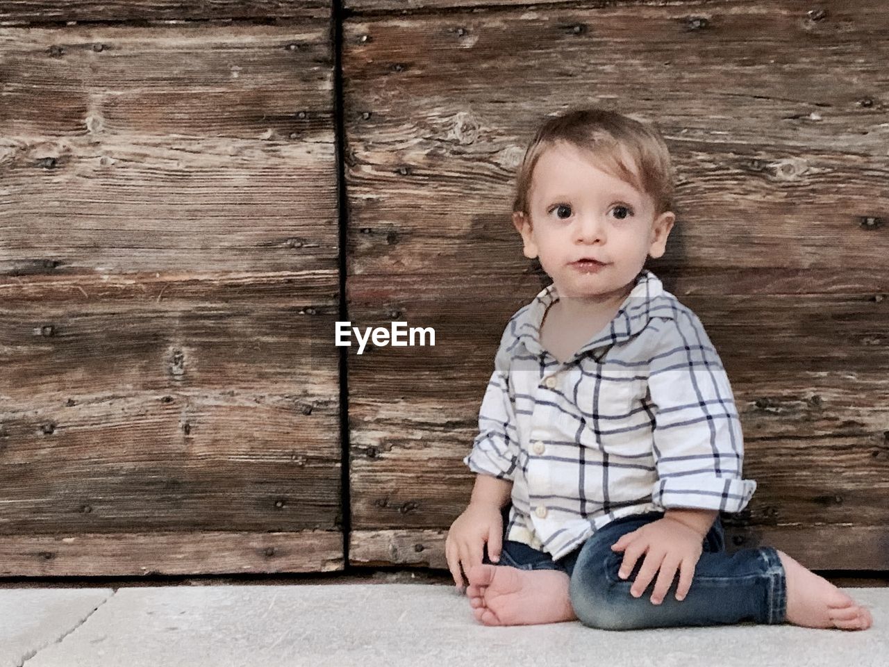 PORTRAIT OF CUTE BABY GIRL SITTING ON WOOD