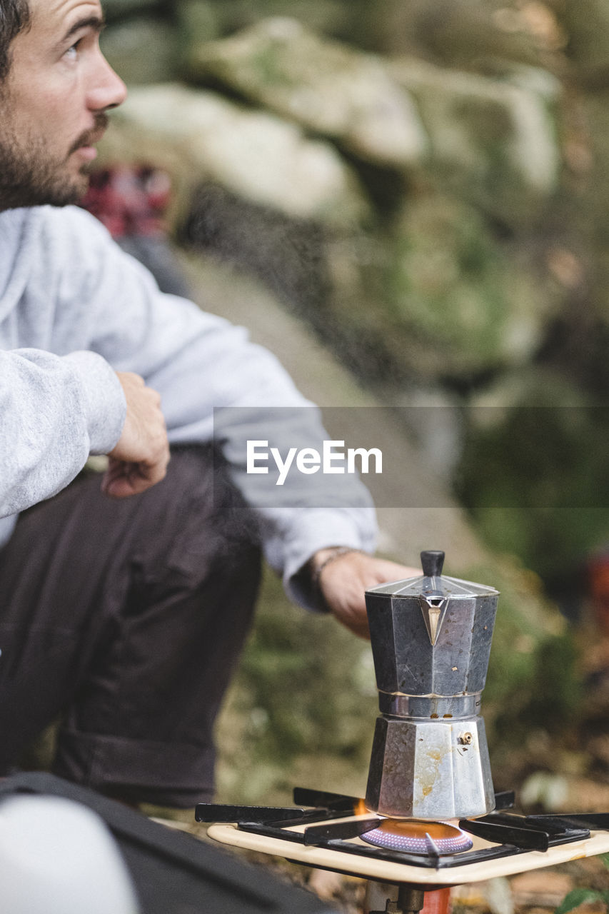 A man prepares coffee outdoors