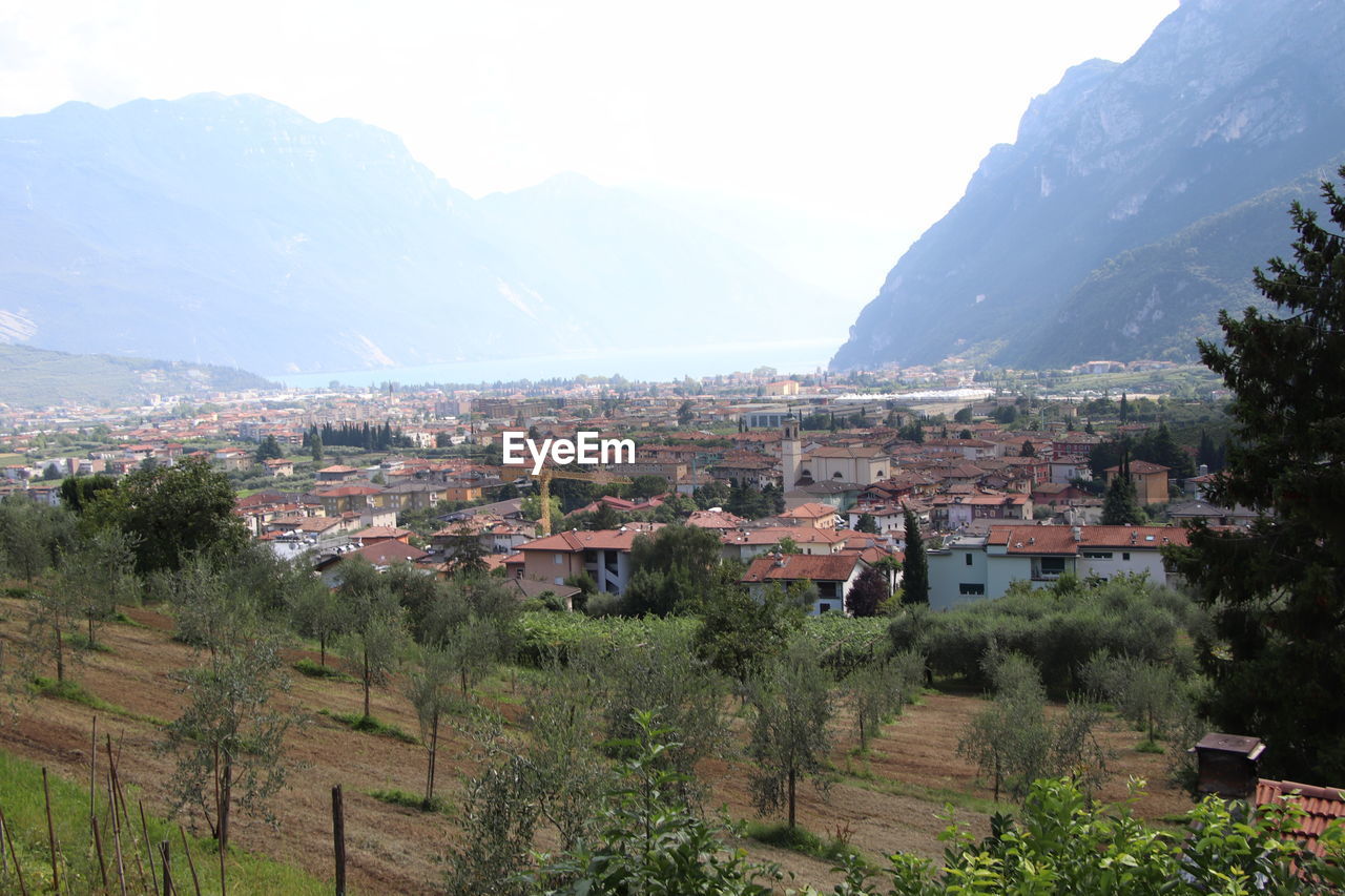 TOWNSCAPE AND MOUNTAINS AGAINST SKY