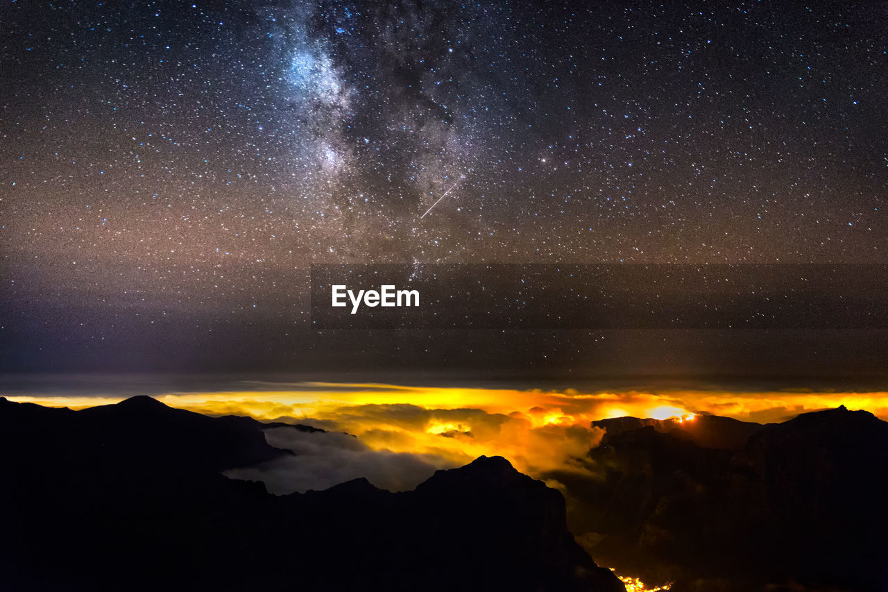 Scenic view of mountains against sky at night