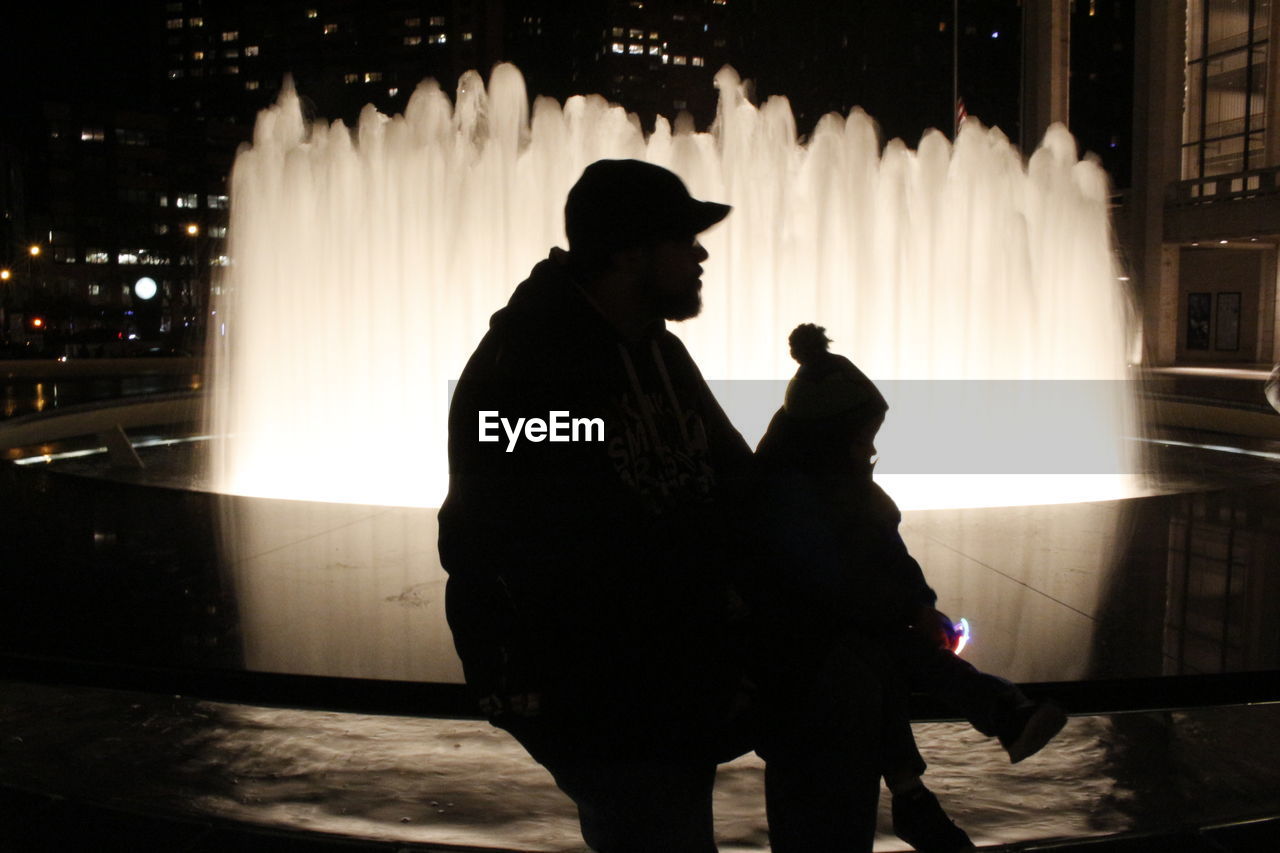 VIEW OF ILLUMINATED PEOPLE AT NIGHT