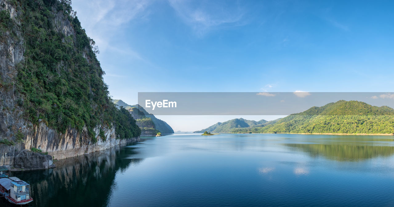 scenic view of lake by mountain against sky