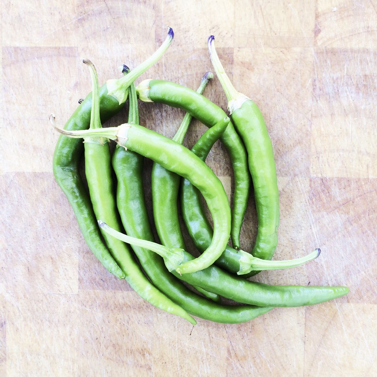 Directly above of fresh green chili peppers on floor