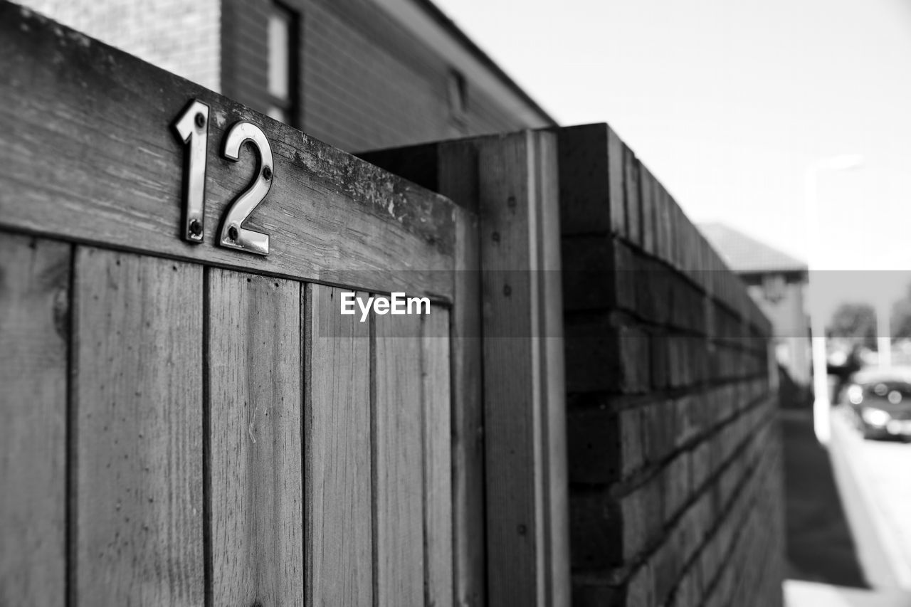 CLOSE-UP OF TEXT ON WOOD AGAINST BUILDING