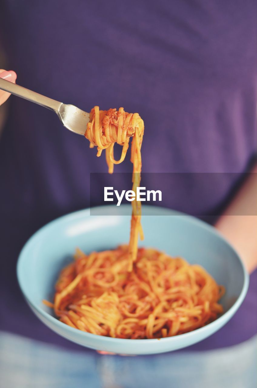 Midsection of woman having pasta