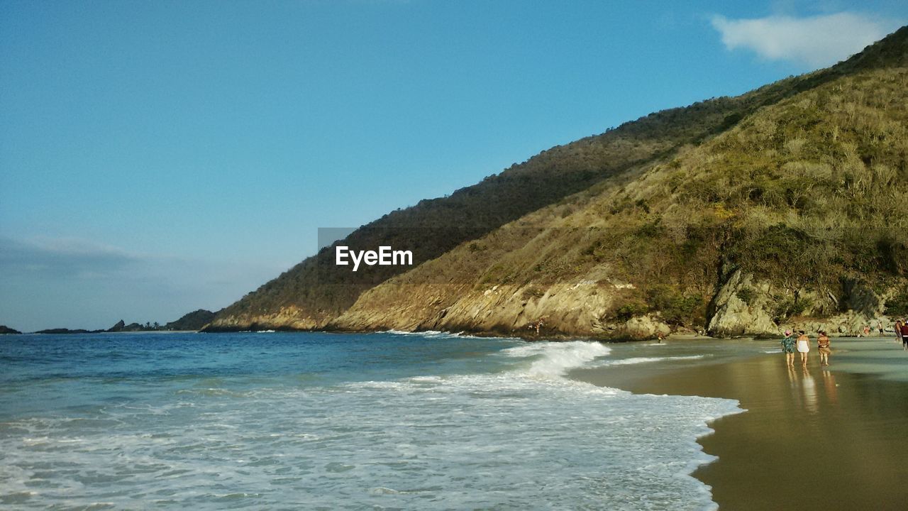 View of calm beach against blue sky