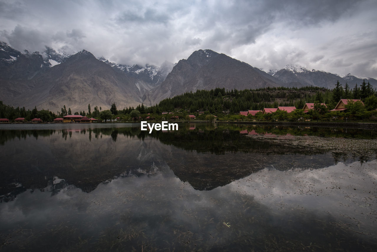 Scenic view of lake by mountains against sky