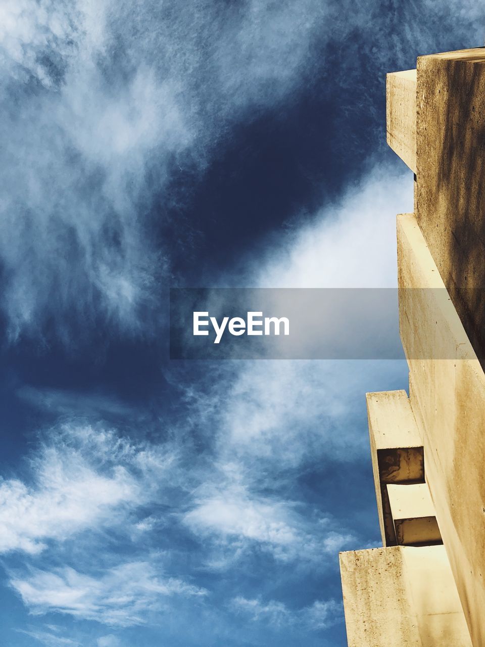 LOW ANGLE VIEW OF BUILDING AGAINST CLOUDY SKY