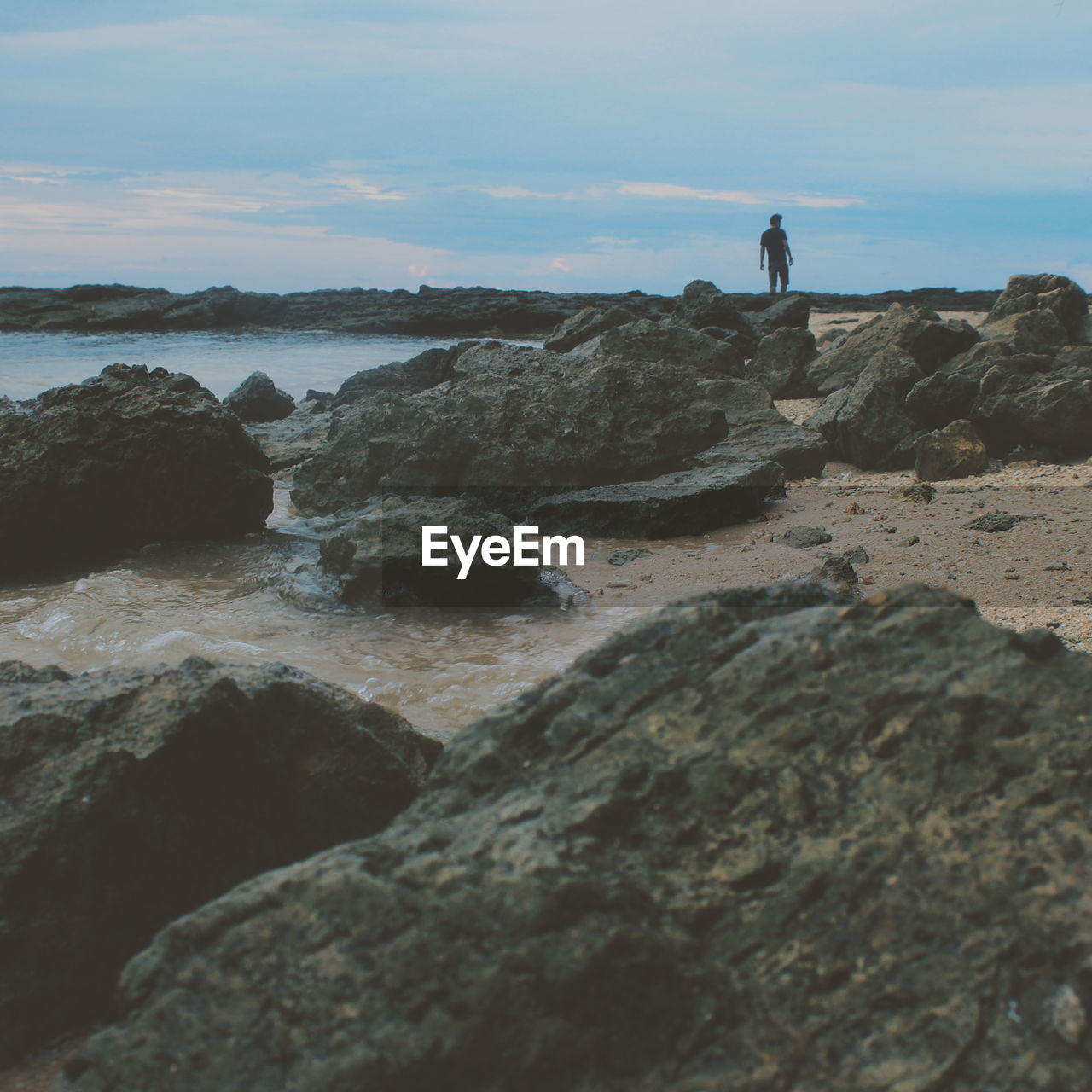 Man standing on rock at seaside