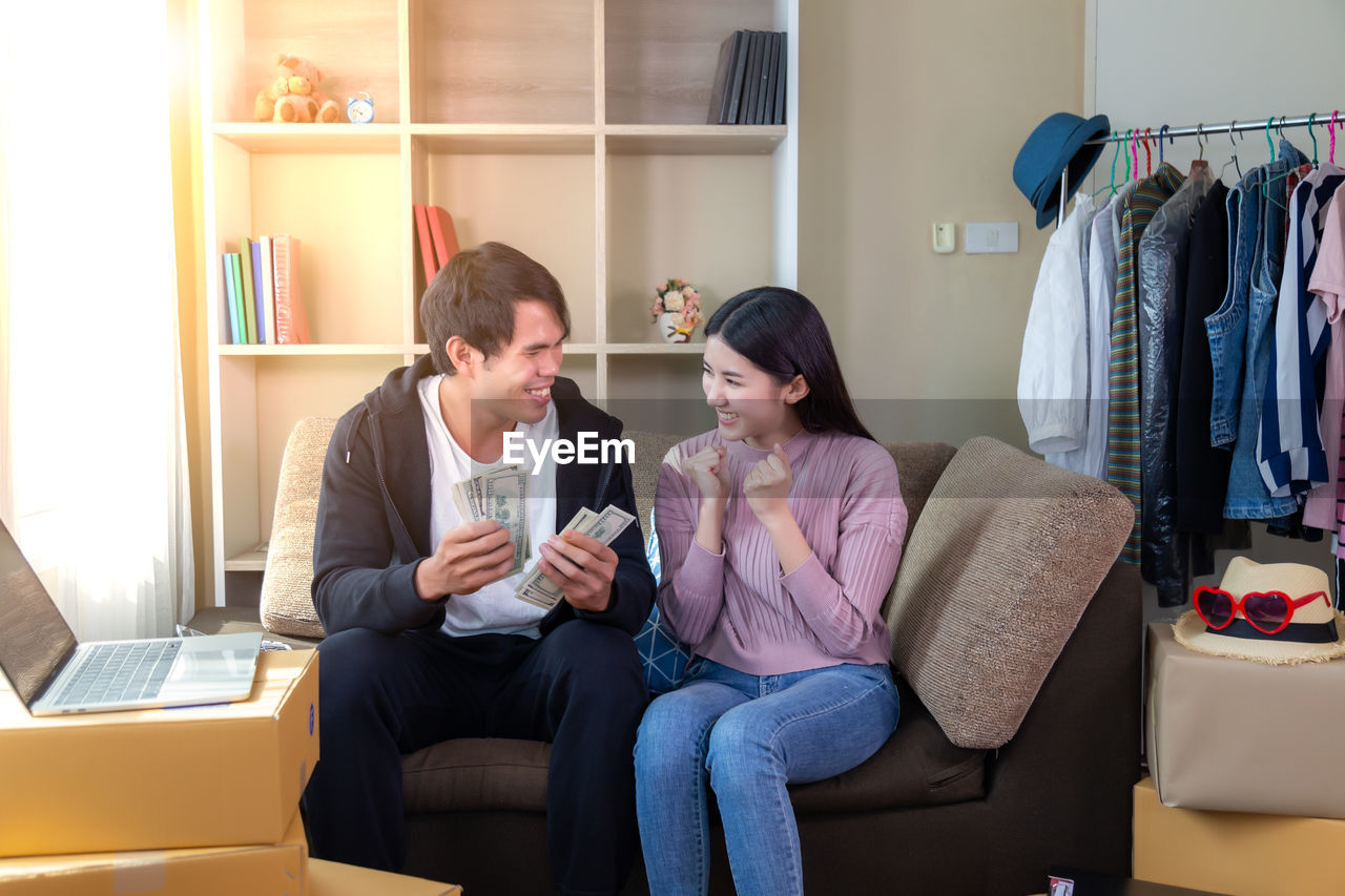 Young couple sitting with currency at home
