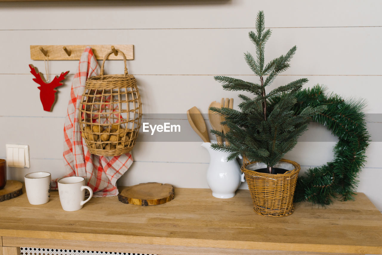 plant, indoors, no people, decoration, food and drink, christmas, holiday, nature, tradition, christmas decoration, potted plant, celebration, interior design, food, tree, container, houseplant, flowerpot, christmas tree, domestic room, table, wood, home interior, hanging, wall - building feature, domestic life, household equipment, basket