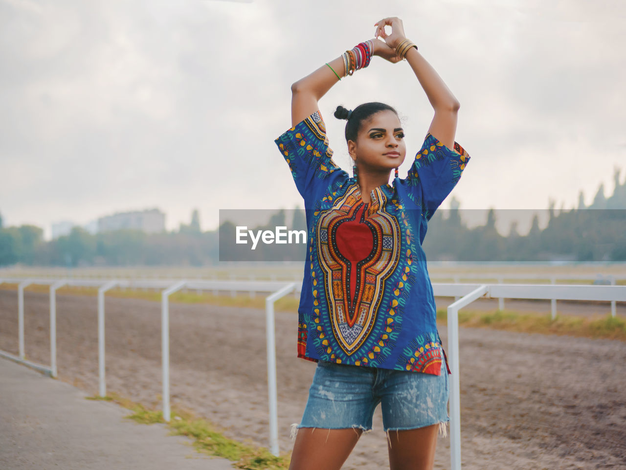 Young woman standing against race course