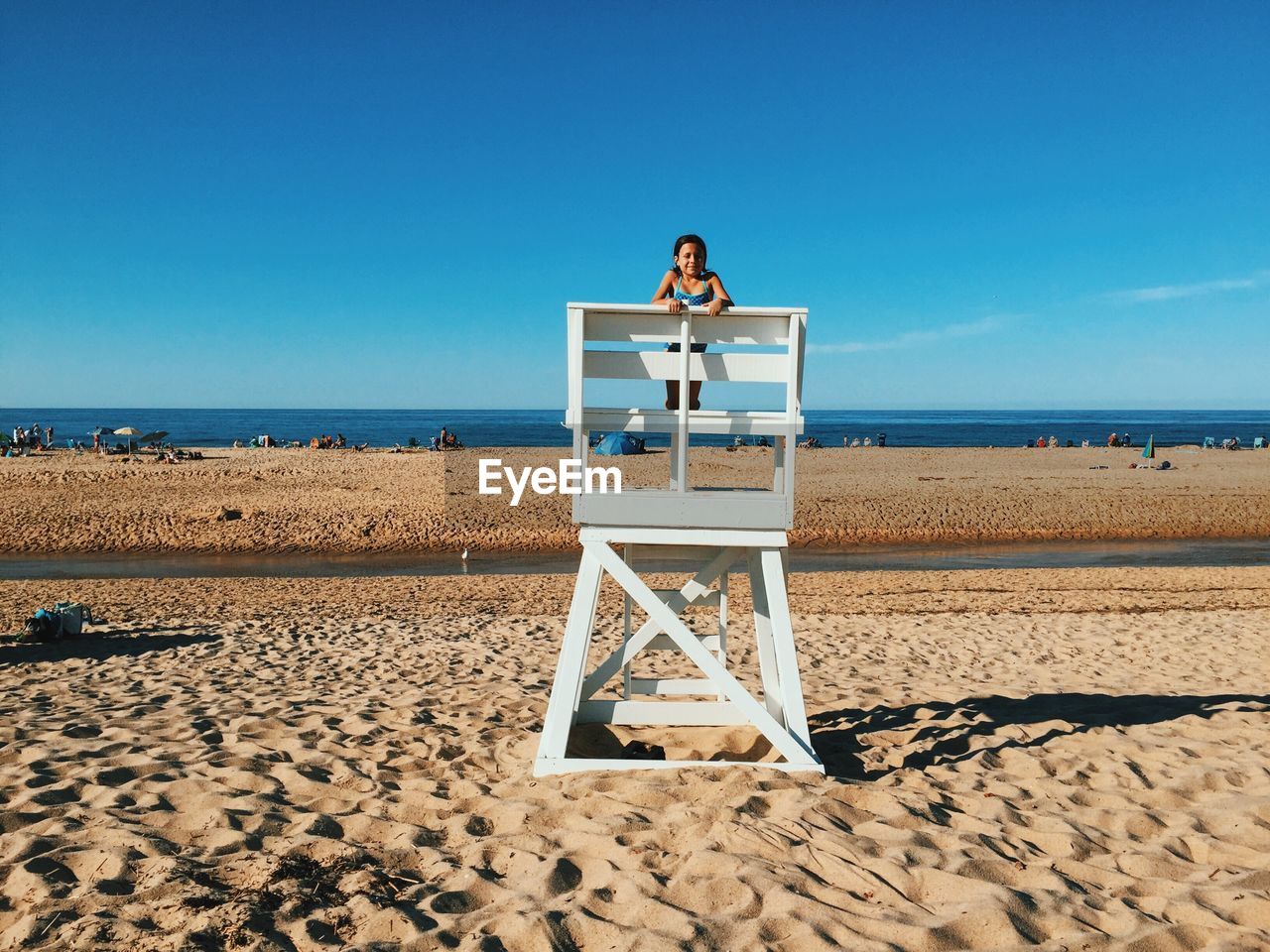 Teenage girl standing on lifeguard hut at beach