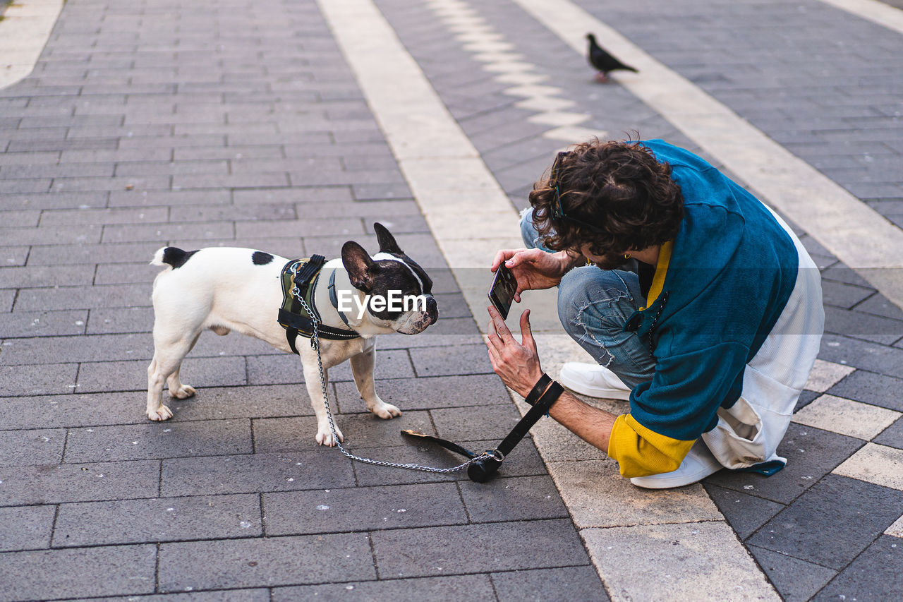 Full length of woman with dog on footpath