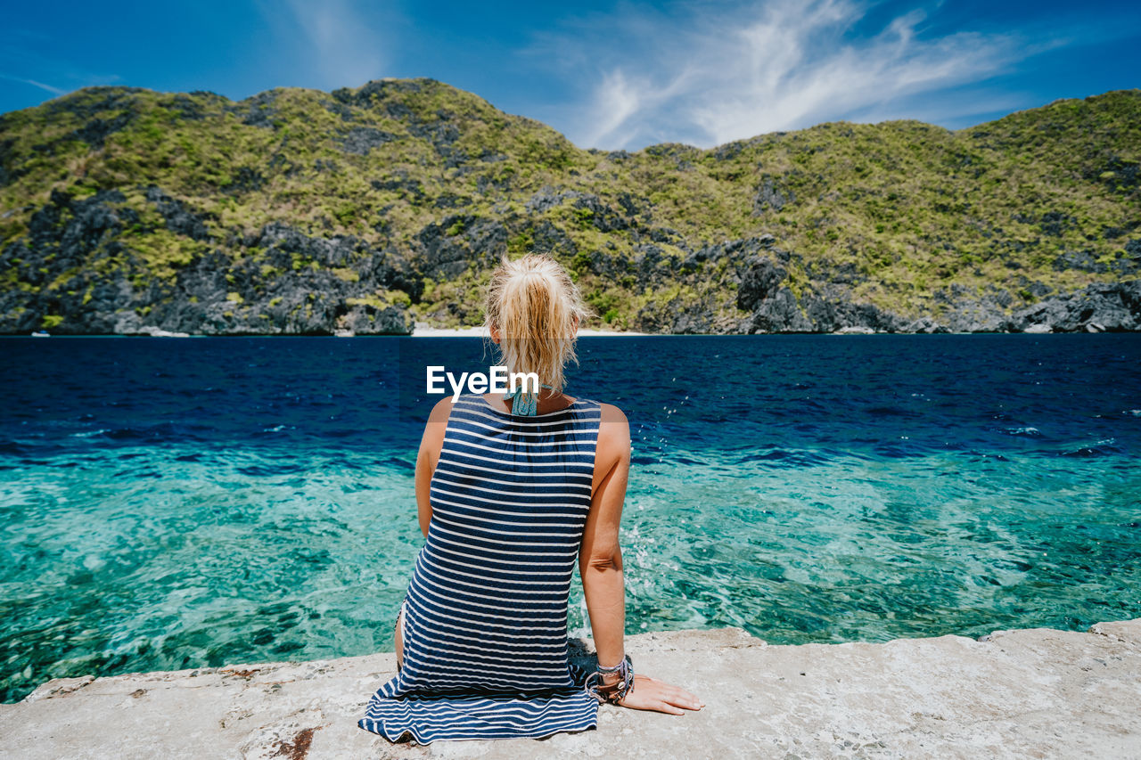 Rear view of woman looking at sea against sky