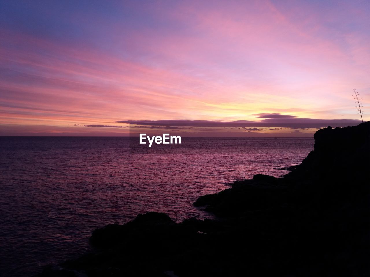 SCENIC VIEW OF SEA AT SUNSET