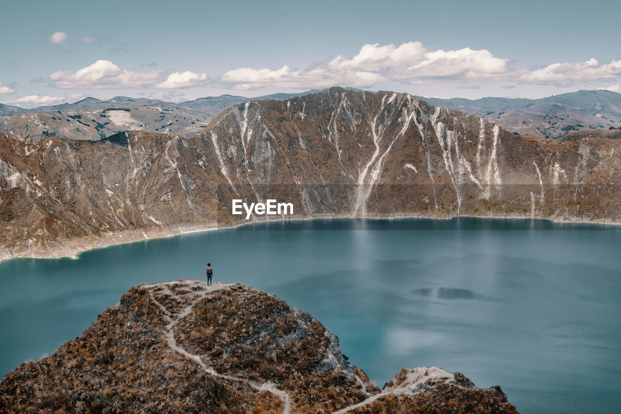 Scenic view of lake and mountains against cloudy sky