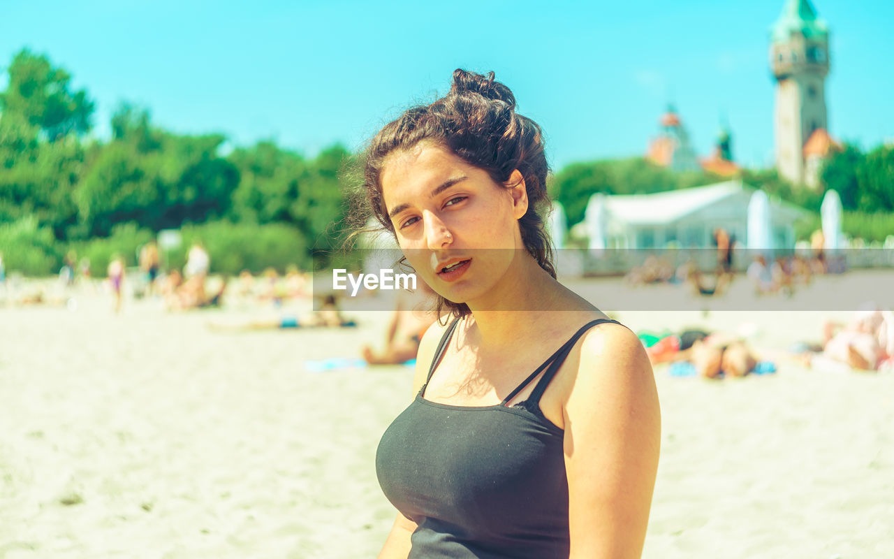 Portrait of young woman at beach during sunny day