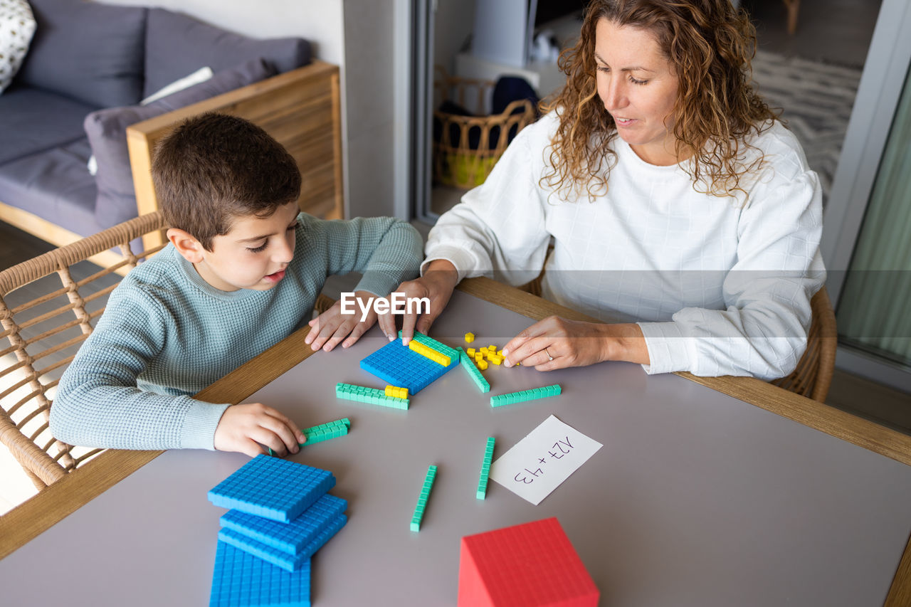 Mother teaching her son math with base 10 method at home