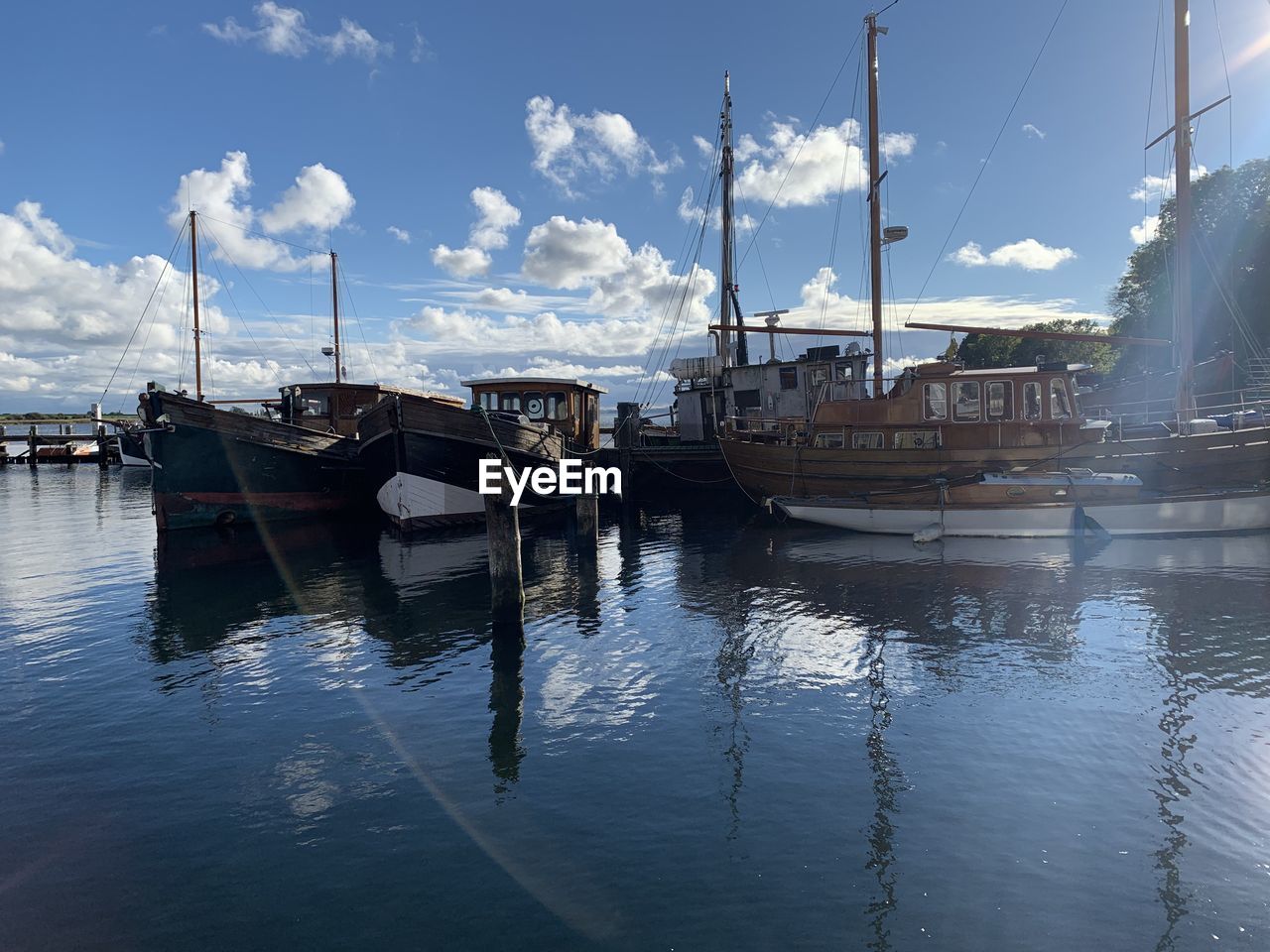 water, nautical vessel, transportation, mode of transportation, sky, reflection, boat, sea, vehicle, dock, cloud, nature, harbor, ship, sailboat, moored, travel, no people, marina, watercraft, travel destinations, architecture, day, outdoors, pole, blue, tranquility, bay, beauty in nature, mast, pier, tourism, holiday, scenics - nature, vacation, sunlight, trip