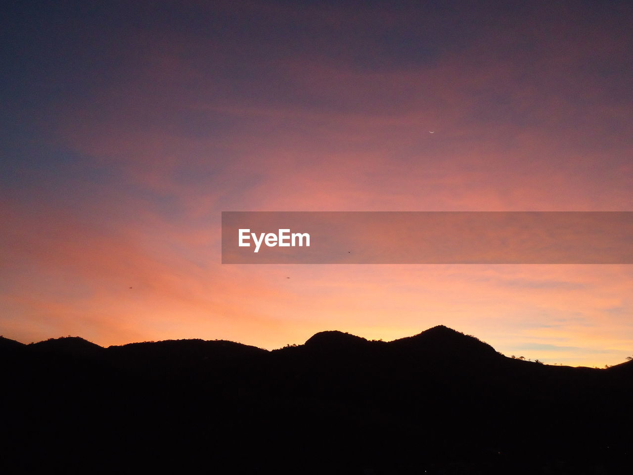 Silhouette mountains against sky at dusk