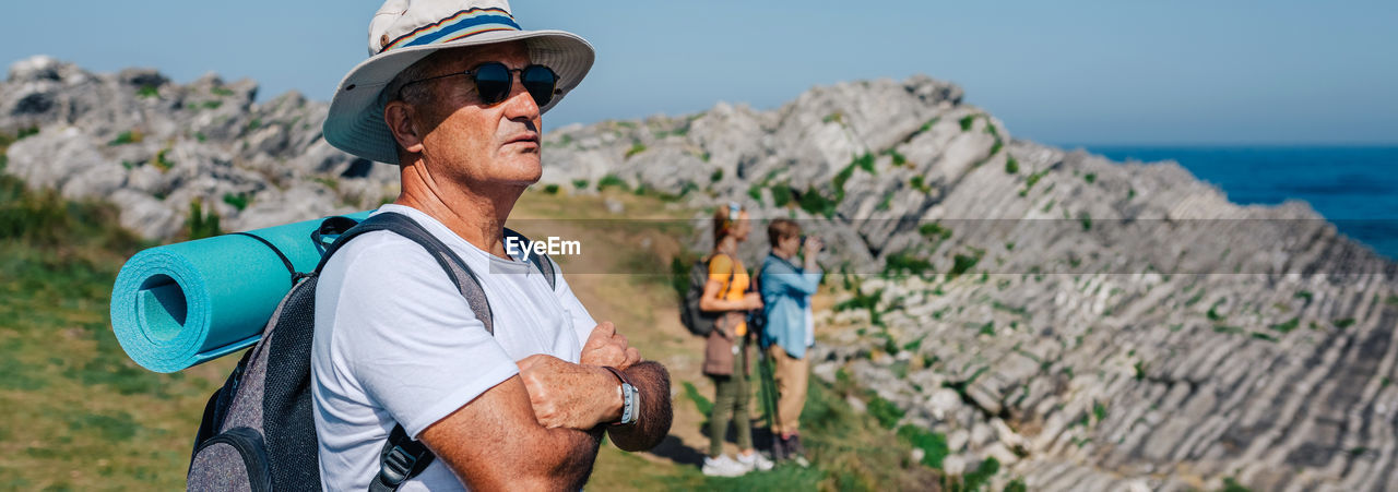 Senior man who practices trekking looking at the landscape