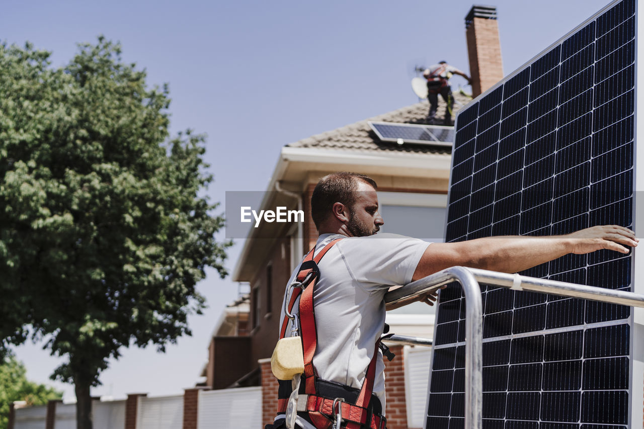 Engineer loading solar panel in hydraulic platform