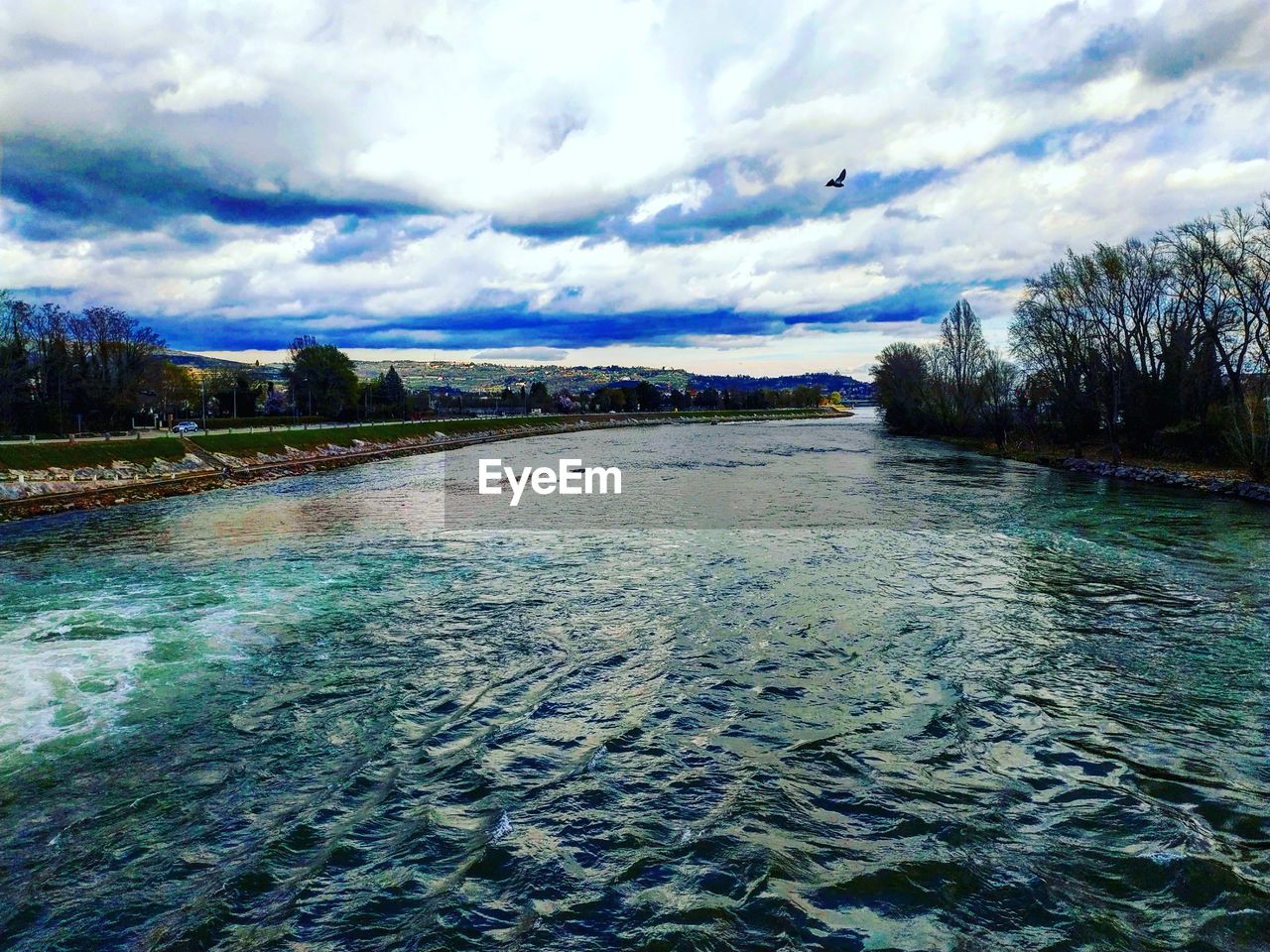 RIVER AMIDST TREES AGAINST SKY